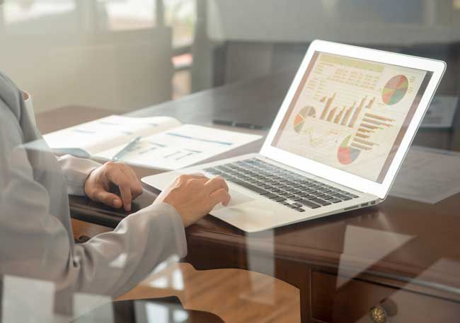 A contractor reviewing data from fuel card analytics on her computer.